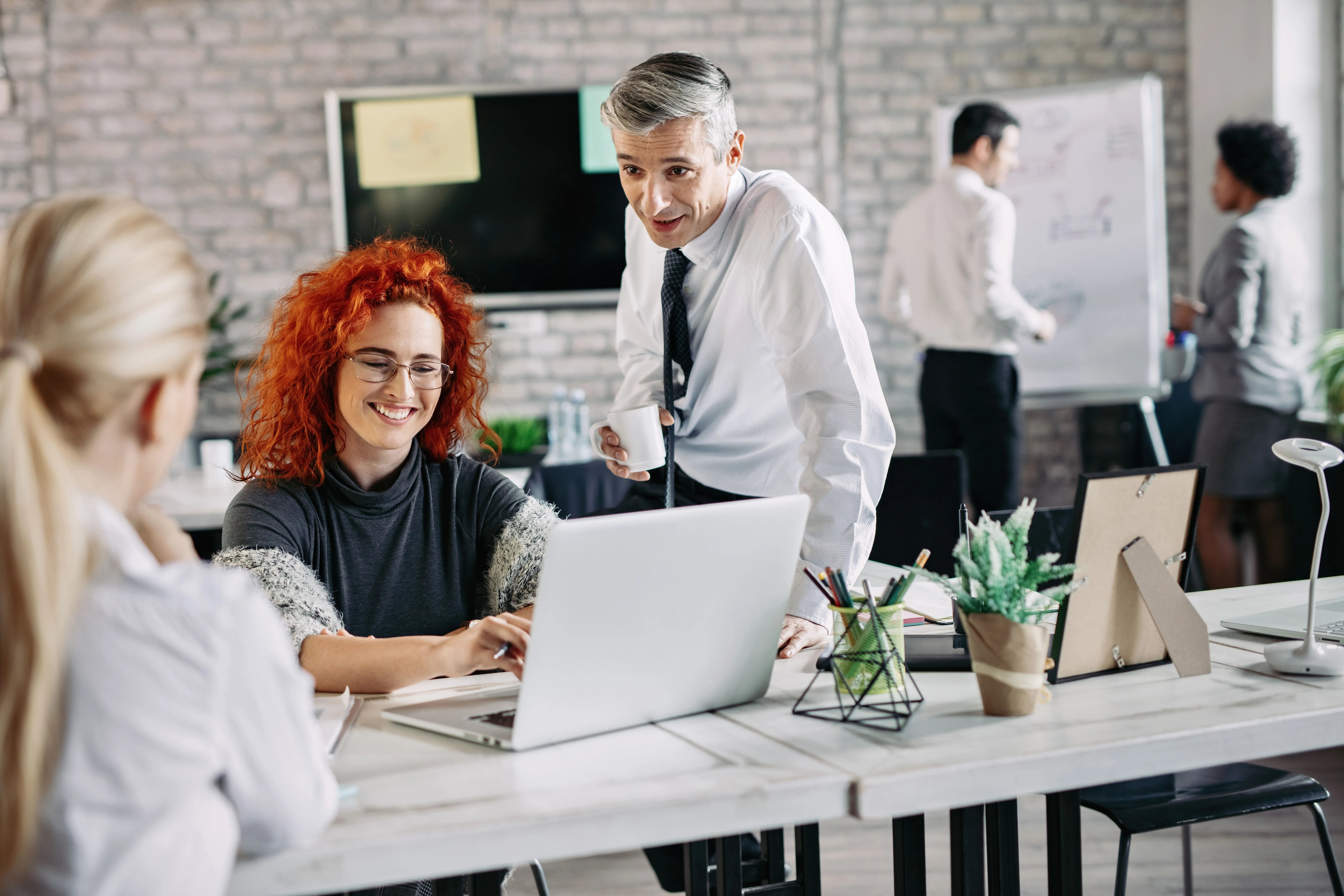 happy business people talking each other while working office